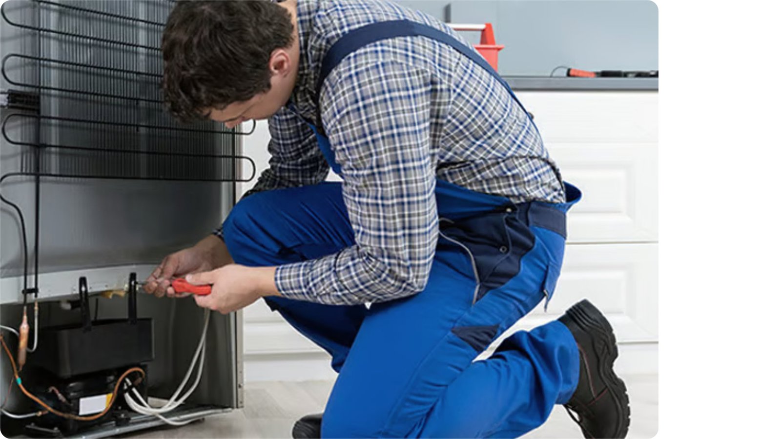 Técnico de RefriCold reparando una heladera en el domicilio del cliente